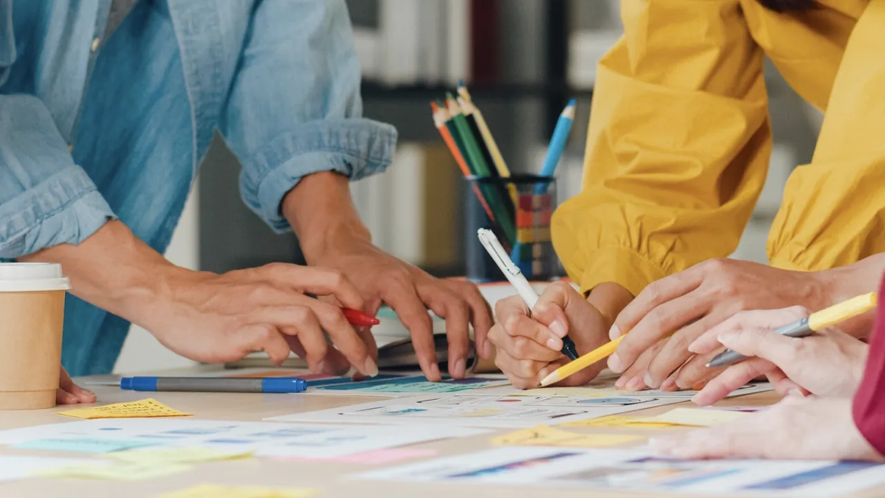 Hands working together on campaign sketches